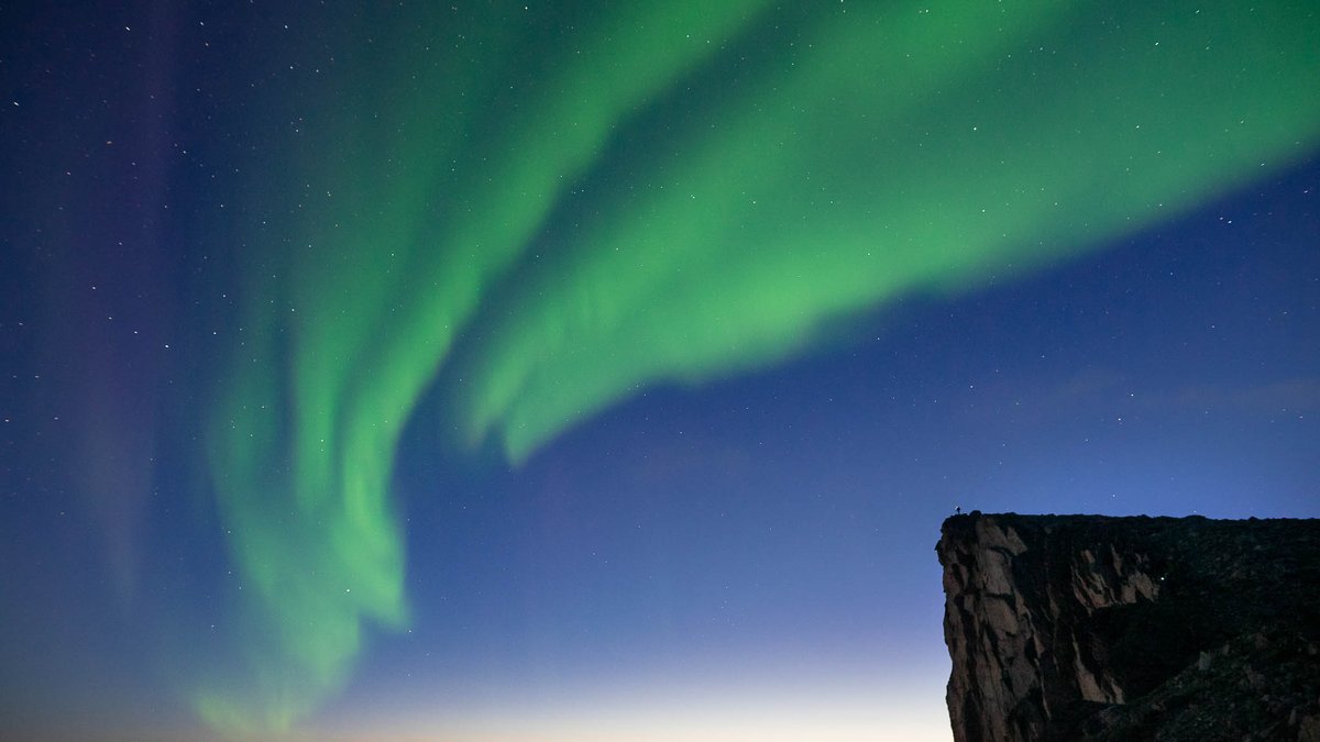 Aurora visible during late twilight over the Norwegian coast, taken in early autumn