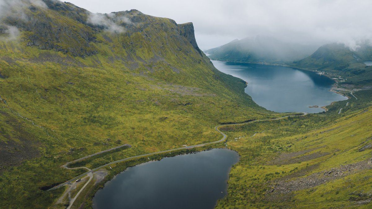 Green valley, lake and fjord on Senja under low cloud in late summer