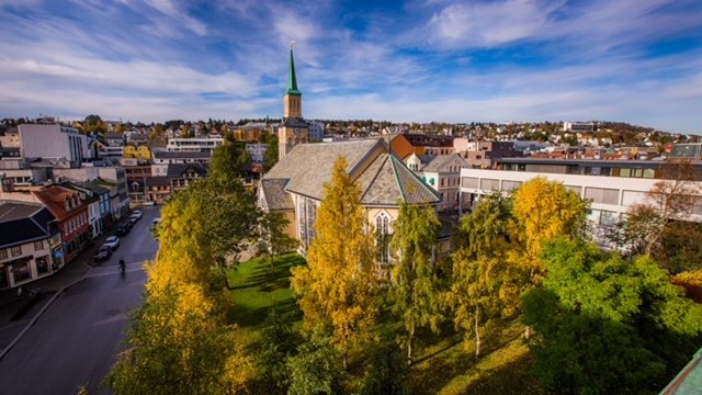 Tromsø city centre and cathedral framed by autumn foliage as summer ends