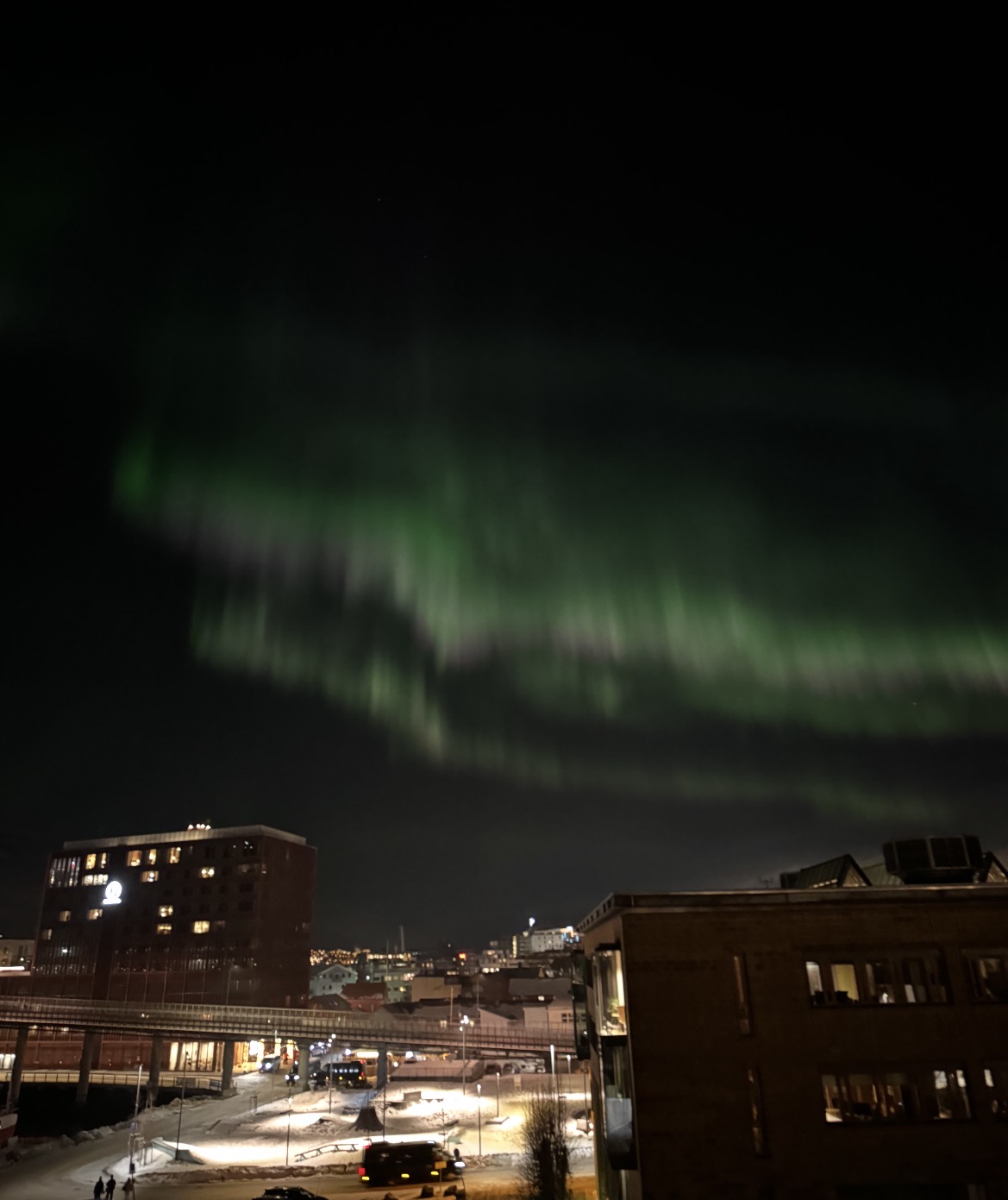 The green northern lights over central Tromsø seen from the Aurora View Apartment