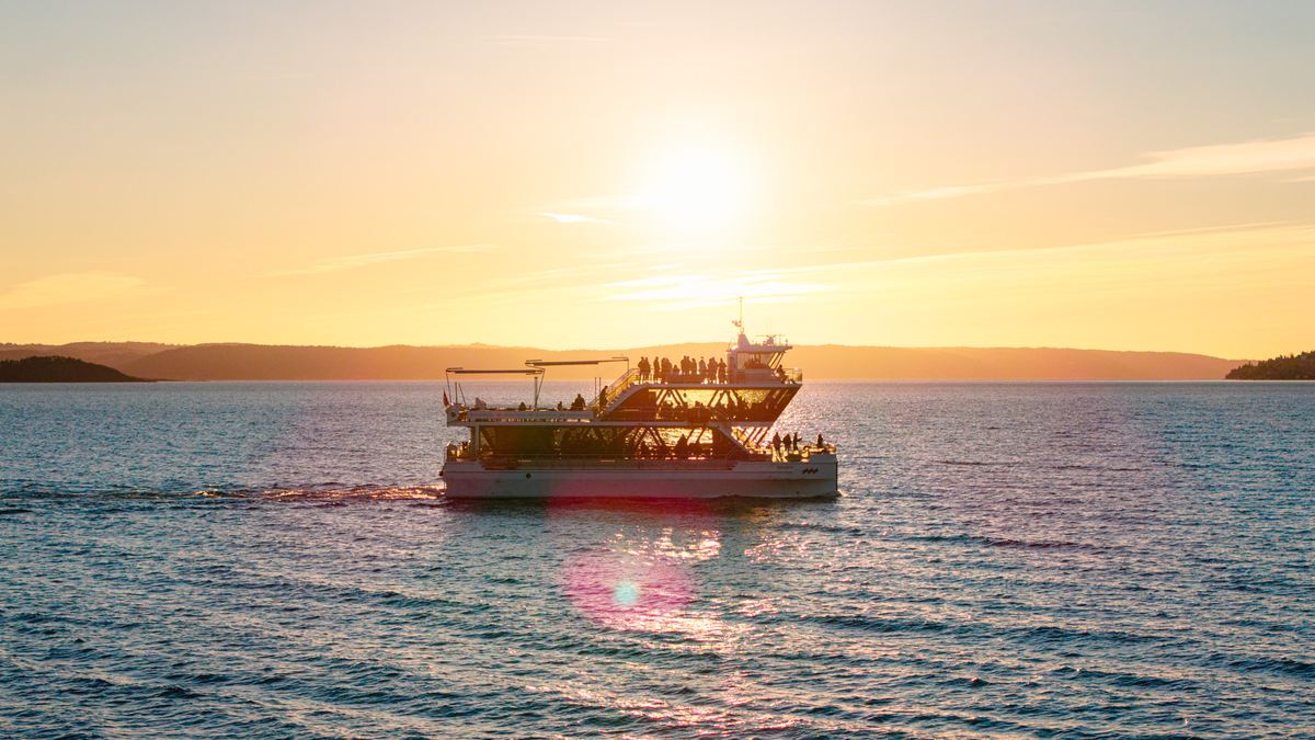 Boat on open water under low evening sun near Tromsø